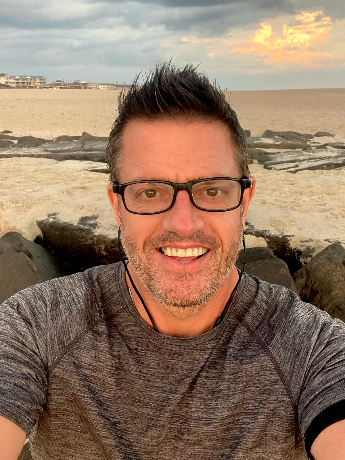 Rob Scott smiling at the beach at sunset