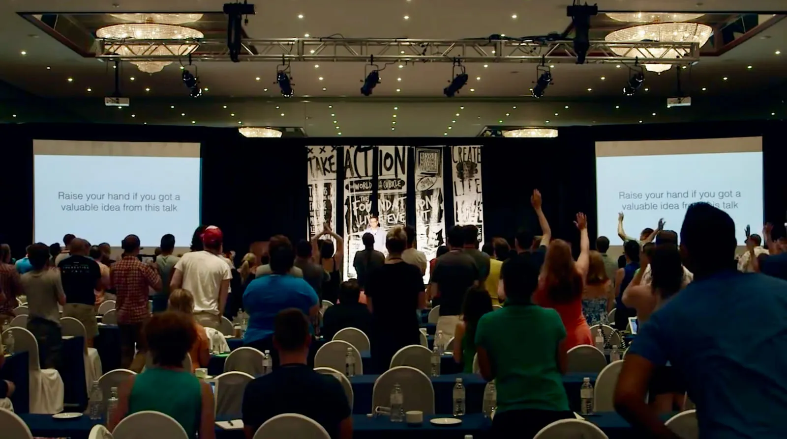 Rob Scott engaging an audience at a live event, hands raised