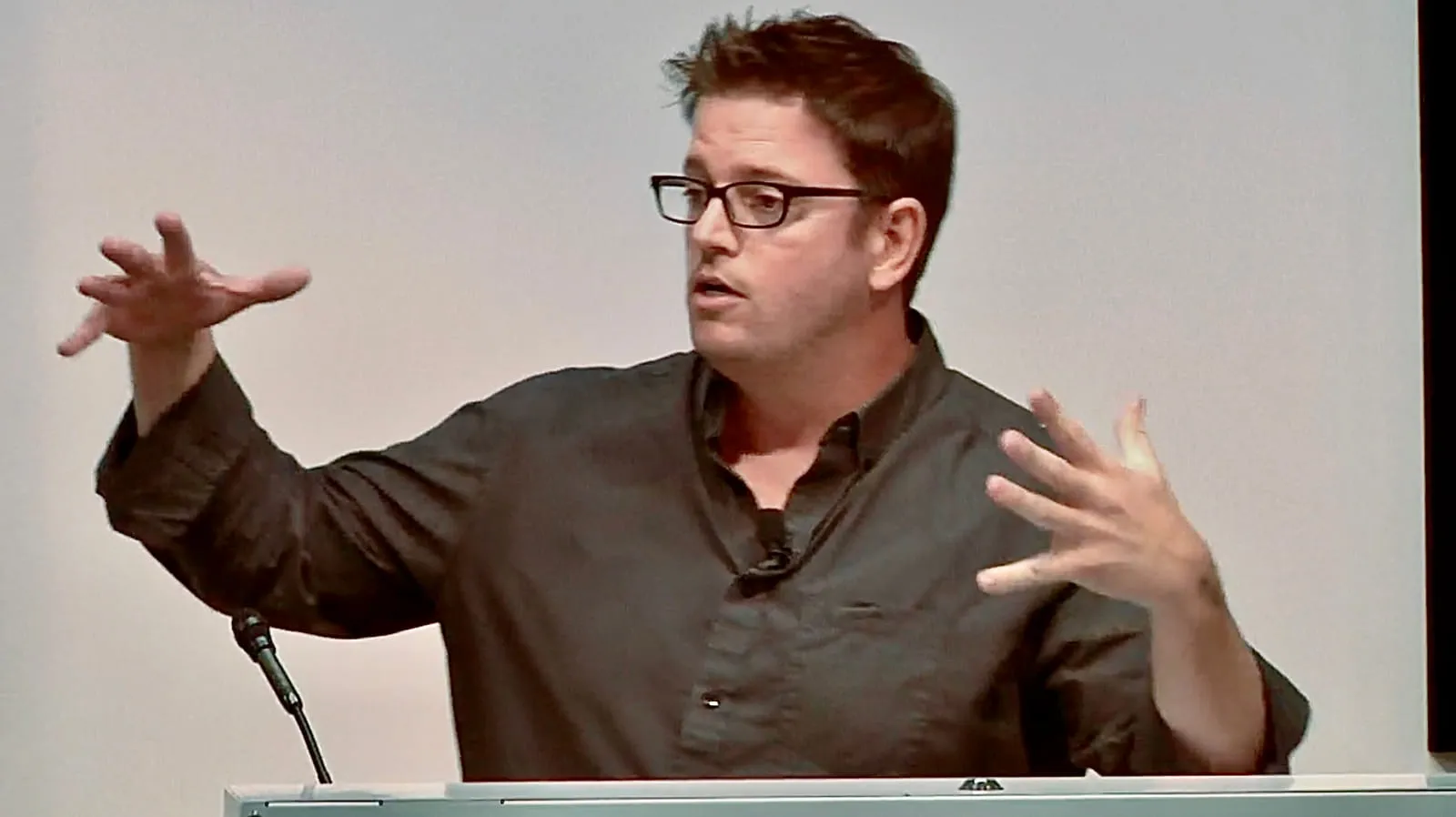 Rob Scott mid-gesture at a lectern, speaking at Google